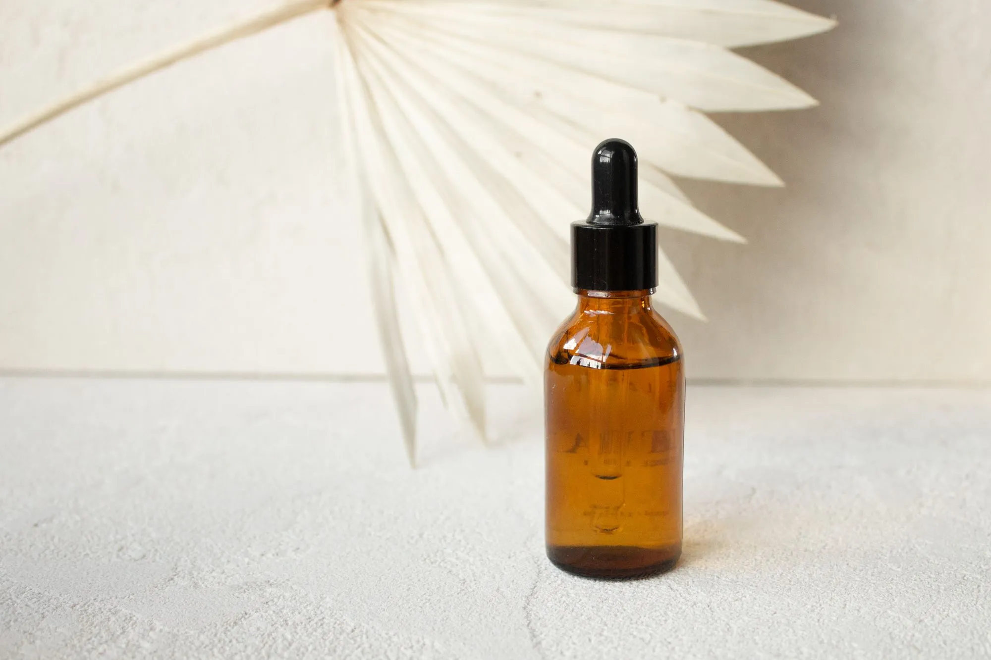 Amber glass dropper bottle on a white surface