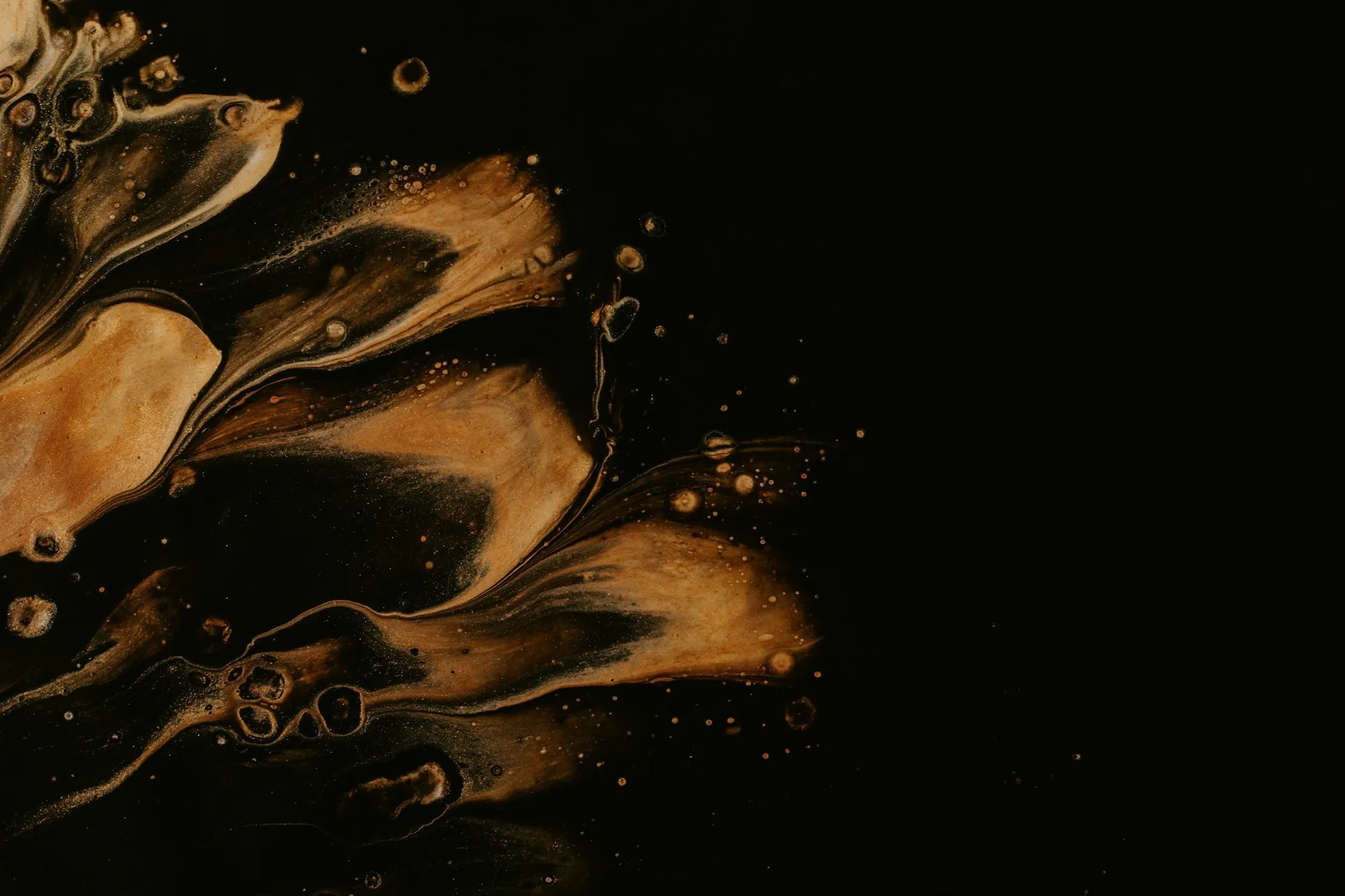 Swirls of golden liquid on black
